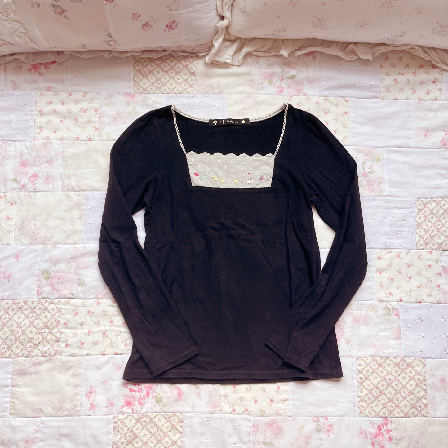 black embroidery accent top
